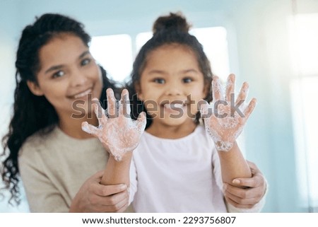 My hands are as happy as I am. Shot of a little girl and her mother washing their hands in a bathroom at home.