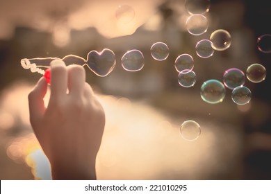  My Heart Bubbles at the sky, sunset,Love in the summer sun with bubble blower,romantic inflating colorful soap bubbles in park - Shutterstock ID 221010295