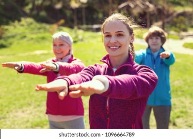 My inspiration. Exuberant sportive woman smiling and training aged people in the open air - Shutterstock ID 1096664789