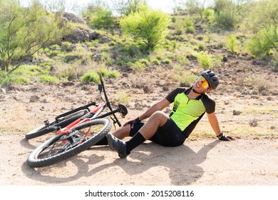 My knee hurts. Pained young cyclist suffering from a leg injury after falling off his mountain bike while practicing outdoors - Powered by Shutterstock