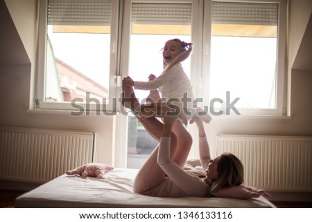 Similar – Happy boy jumping and playing over the bed with his family in a relaxed morning. Weekend family leisure time concept.