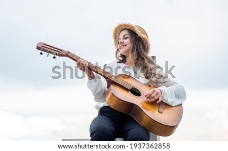 my new song. singer. happy teen girl playing guitar outdoor. happy childhood.