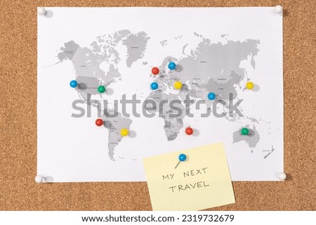 My next travel destination concept. Pushpins on world map on Corkboard and yellow sticky note