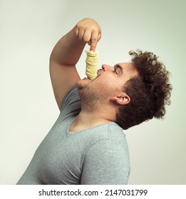 For My Next Trick I Will Make These Chips Disappear. Studio Shot Of An Overweight Man Shoving A Stack Of Chips Down His Throat.