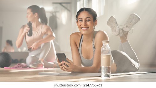 My Virtual Personal Trainer Gives Me All The Help I Need. Shot Of Two Young Female Athletes Taking A Break While At The Gym.