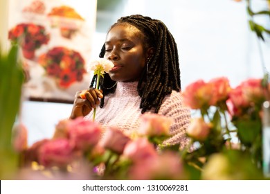 My workplace. Cheerful female person keeping eyes closed while smelling flower - Powered by Shutterstock