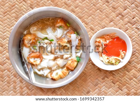 Myanmar homemade Lor Mee recipe in steel dish and chili sauce with chopped garbage. Lor mee is a Chinese, Indonesian or Malaysian noodle dish served in thick starchy gravy and flat yellow noodles.