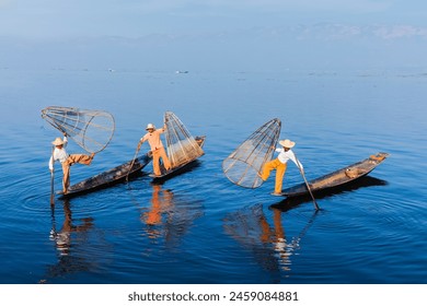 Myanmar travel attraction landmark - Traditional Burmese fishermen balancing with fishing net on boats at Inle lake in Myanmar famous for their distinctive one legged rowing style - Powered by Shutterstock