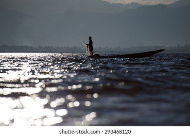 Myanmar travel attraction landmark - Traditional Burmese fisherman at Inle lake, Myanmar famous for their distinctive one legged rowing style - Powered by Shutterstock