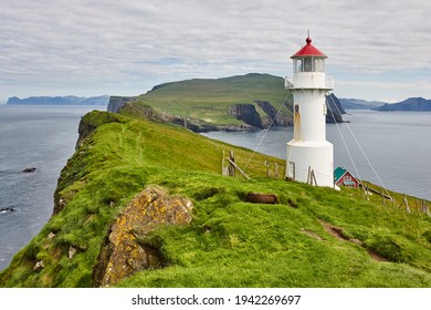 Mykines Lighthouse And Cliffs On Faroe Islands. Hiking Landmark. Denmark