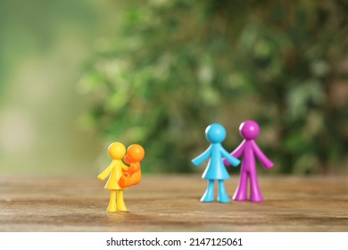 MYKOLAIV, UKRAINE - JANUARY 04, 2022: Colorful Human Figures On Wooden Table Against Blurred Green Background. Surrogacy Concept