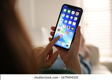MYKOLAIV, UKRAINE - MARCH 16, 2020: Woman holding iPhone 11 with home screen indoors, closeup