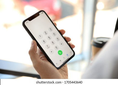 MYKOLAIV, UKRAINE - MARCH 16, 2020: Man Holding IPhone 11 With Keypad On Screen Indoors, Closeup