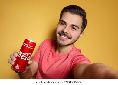 MYKOLAIV, UKRAINE - NOVEMBER 28, 2018: Young man taking selfie with Coca-Cola can on color background