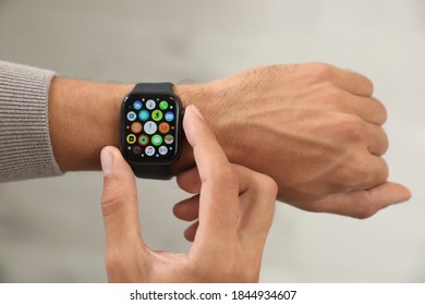 MYKOLAIV, UKRAINE - OCTOBER 04, 2019: Man Using Apple Watch On Light Background. Closeup