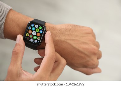 MYKOLAIV, UKRAINE - OCTOBER 04, 2019: Man Using Apple Watch On Light Background, Closeup