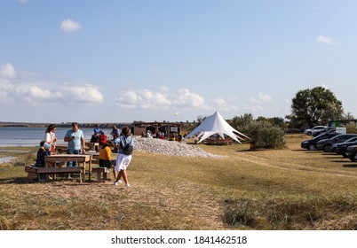 Mykolaiv, Ukraine - September 19, 2020: Seniors and young people having dinner at river restaurant "Scifian Oysters" near the riverside. Outdoor holiday vacation