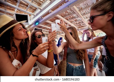 Mykonos, Greece 25 July 2015 Girls Are  In The Beach Party And Drinking Yeni Raki As A Apéritif Which Is A Sweetened, Often Anise-flavoured, Alcoholic Drink From Turkey. Popular In Greece And Balkans