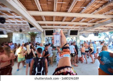 Mykonos, Greece 25 July 2015 Girls Are  In The Beach Party And Drinking Yeni Raki As A Apéritif Which Is A Sweetened, Often Anise-flavoured, Alcoholic Drink From Turkey. Popular In Greece And Balkans