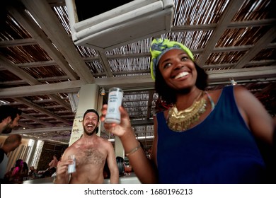 Mykonos, Greece 25 July 2015 Girls Are  In The Beach Party And Drinking Yeni Raki As A Apéritif Which Is A Sweetened, Often Anise-flavoured, Alcoholic Drink From Turkey. Popular In Greece And Balkans