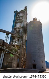 Mynaral/Kazakhstan - April 04 2012: Jambyl Cement Plant. Silhouette Of Main Cement Tower, Clinker Kiln, Tubes And Cylinder Concrete Tower (silo). 