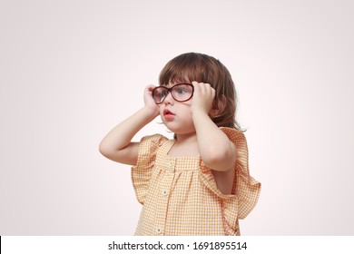 Myopia In Children. Portrait Of Beautiful Little Girl Wearing Glasses On Grey Background. Vision, Health, Ophthalmology Concept.