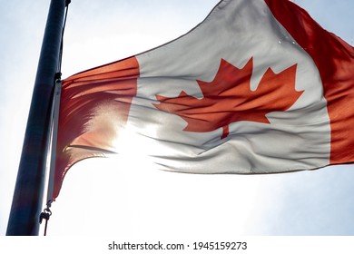 MYRTLE BEACH, SOUTH CAROLINA - MARCH 28, 2021: A Red And White Canadian Flag Waves In The Sunlight While On A Flag Pole.