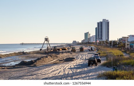 Myrtle Beach, South Carolina, United States - October 29, 2018: Construction Crew Laying Out Pipeline On The Sandy Beach During A Sunny Sunset.