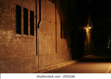 Mysterious Alley - Dark Abandoned Street With Lights Shining On A Brick Wall - Shutterstock ID 2922160