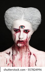 Mysterious beauty portrait of snow queen covered with blood. Bright luxury makeup. Gore dripping from the mouth