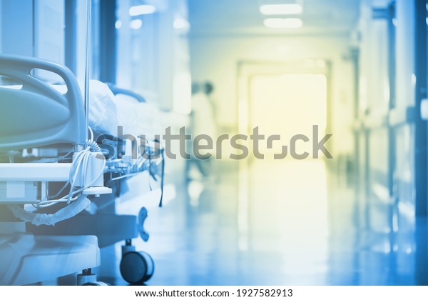 Mysterious, enchanting light in a hospital\
hallway with a bed in the\
foreground.