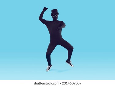 Mysterious faceless man dressed in black bodysuit dancing. Full length portrait of disguised man wearing full body spandex costume, bowler hat and sunglasses having fun over isolated studio background - Powered by Shutterstock