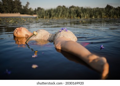 Mysterious And Fashion Portrait Of Young Woman Lying In Water With Face