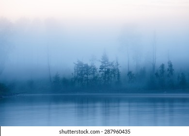Mysterious and foggy night with tree silhouettes at Heposaari island in Ladoga lake, Karelia, North-West of Russia