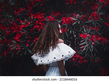 Mysterious girl in a fairy garden with flowers. Сute charming girl, Spain, Mallorca. Attractive brunette with curly hair woman wears white dress. Mysterious atmosphere. Girl in a white dress. - Shutterstock ID 2118646016