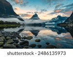 Mysterious landscape of Milford Sound or Rahotu with Mitre peak in foggy on the lake during the morning at Fiordland national park, New Zealand