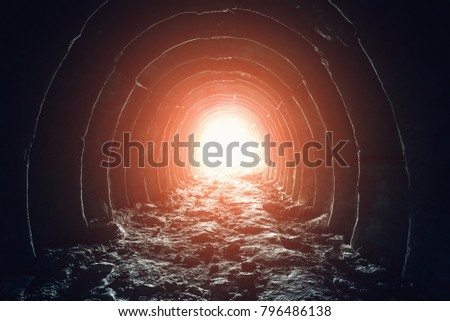 Mysterious light in the end of tunnel. Escape and exit to freedom and hope concept. Abandoned industrial corridor in chalk mine, toned