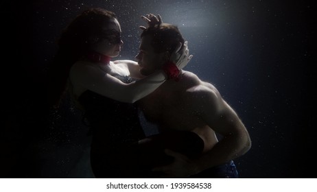 Mysterious Lovers Are Hugging And Floating Underwater, Slow Motion Shot, Woman In Bdsm Suit