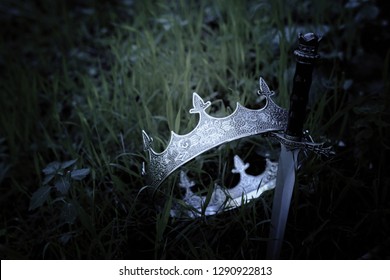 Mysterious And Magical Photo Of Silver King Crown And Sword In The England Woods Or Field Landscape. Medieval Period Concept