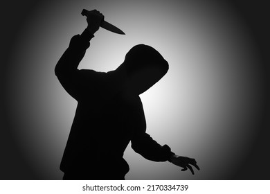 Mysterious Man Wearing Black Hoodie Holding A Knife To Stab Someone. Crimes And Criminality Concept