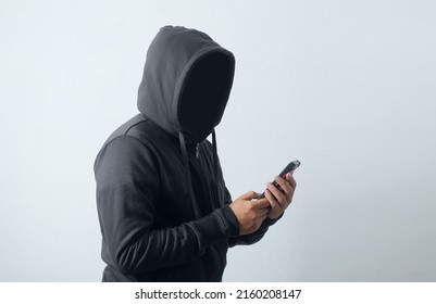 mysterious man wearing hoodie and holding phone