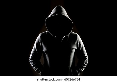 Mysterious man wit hoodie in silhouette isolated on black background - Shutterstock ID 607266734