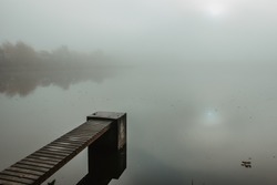 Mysterious Morning By Lake. Foggy Autumn Mystery Atmosphere. Wooden Pier On The Pond.Magic Mood. Misty Fall Day. Speechless Place. Relaxing Meditation Without People.Silence Scene.Serenity Background