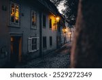 Mysterious old tiny cobble street in Prague on Novy Svet during sunset in autumn with warm lights, which contrast with blue-grey color of the upcoming night evokes coziness, hygge, silent, peace.