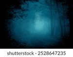 Mysterious pathway through the dark foggy forest in cold tones. Halloween background.