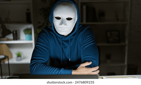 Mysterious person in mask sitting in room during nighttime, evoking suspense. - Powered by Shutterstock