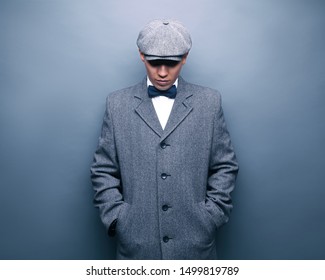 Mysterious portrait of retro 1920s english gangster with flat cap.