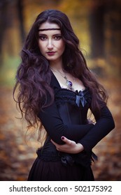  Mysterious portrait. Witch casts a spell. Twilight magic forest.
Dark fantasy sorceress woman.Halloween Witch with a magic Pumpkin in a dark forest.  Fairytales. Halloween. Vampire. Gothic.