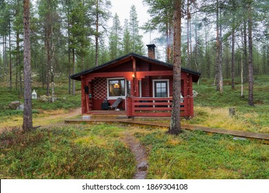 Mysterious red wooden cottage in Inari, Lapland, Finland on foggy autumn day in idyllic pine forest. Lonely cabin for peaceful relaxing holiday in spooky woodland  - Powered by Shutterstock