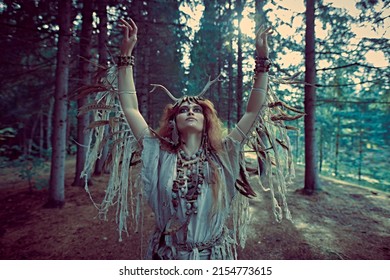 Mysterious Shaman Woman In Ritual Garment Performs An Ancient Shamanic Ritual In The Forest. Fairy Forest Witch. Fantasy. Halloween. 